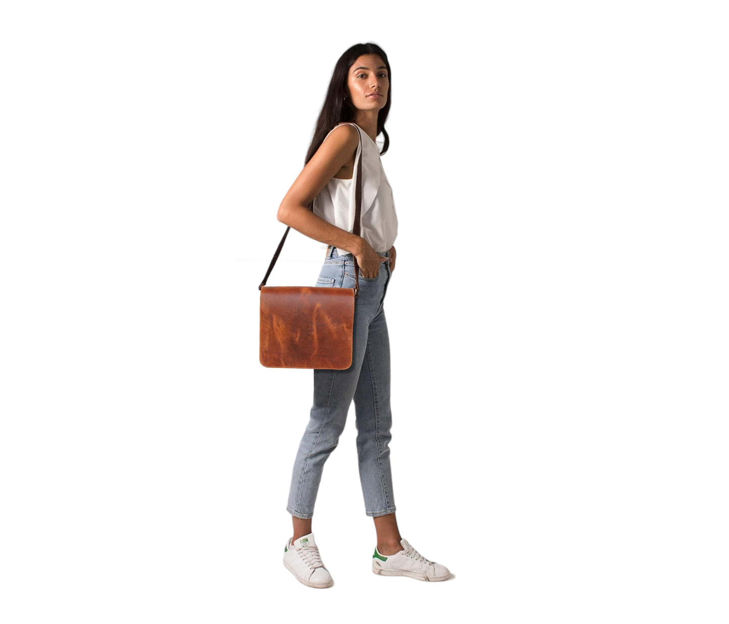 This Image Showcases A Confident Young Woman Effortlessly Styling Handcrafted Leather Messenger Bag, Worn Over The Shoulder For Sleek, Minimalist Look. Bag’s Rich Tan-brown Adds Touch Of Vintage Charm To Her Casual Outfit—white Sleeveless Top, High-waisted Jeans, And Classic White Sneakers—perfectly Balancing Fashion With Function. Its Clean Silhouette Versatile Design Make It Suitable Both Professional Everyday Use. Perfect Personalized Gift Women Men Alike, Bag Is Ideal Birthdays, Graduations, Or Anyone