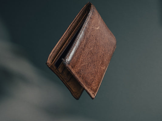 Slim full-grain leather wallet on a wooden surface showing card slots and natural texture