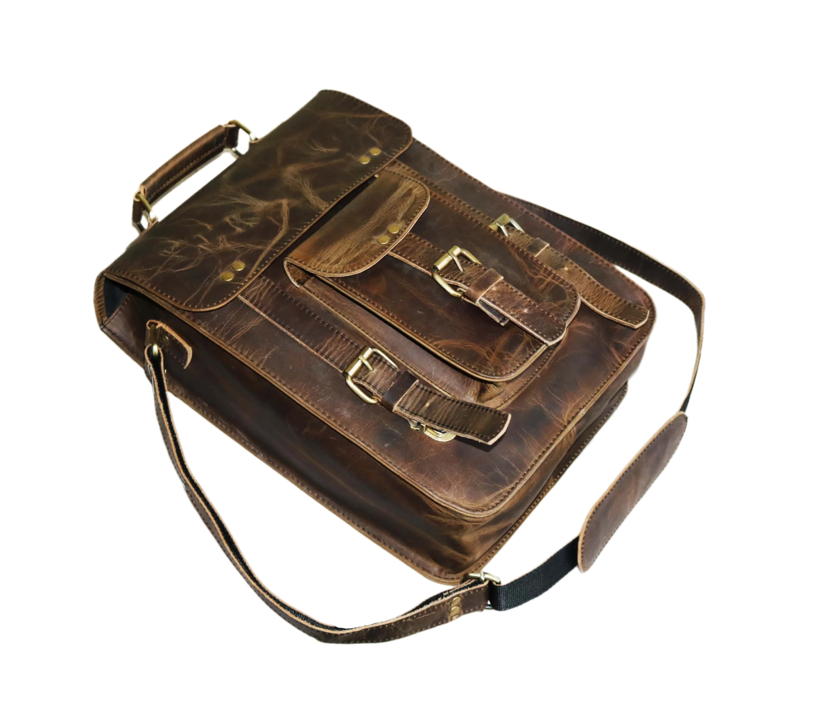 This Image Displays A Vintage-style Sling Leather Bag LaThis Imageid At An Angle, Highlighting Its Rich Craftsmanship And Sturdy Build. Made From Dark Brown Buffalo Leather, The Bag Features Natural Grain Patterns And A Rugged Finish That Adds To Its Timeless Appeal. The Front Flap Is Secured With Dual Buckle Straps, While A Smaller Pocket Below Provides Additional Storage With Its Own Buckle Closure. Brass-polished Hardware Enhances Both The Durability And Classic Aesthetic Of The Bag. A Strong Top Handle

