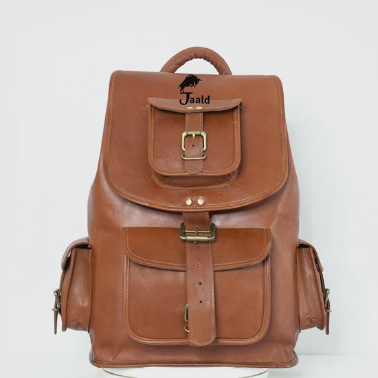 Crafted From Rich, Full-grain Tan Leather, This Vintage-style Rucksack By Jaald Is A Perfect Personalized Or Customized Gift For Men And Women. With Spacious Main Compartment Flap Buckle Closure, It Offers Secure Storage Classic Charm. Front Side Pockets Brass Buckles Allow Easy Access To Essentials, While The Sturdy Top Handle Padded Shoulder Straps Ensure Comfort. Timeless Graduation Gift, Birthday Travel Companion Blending Durability Old-world Elegance.